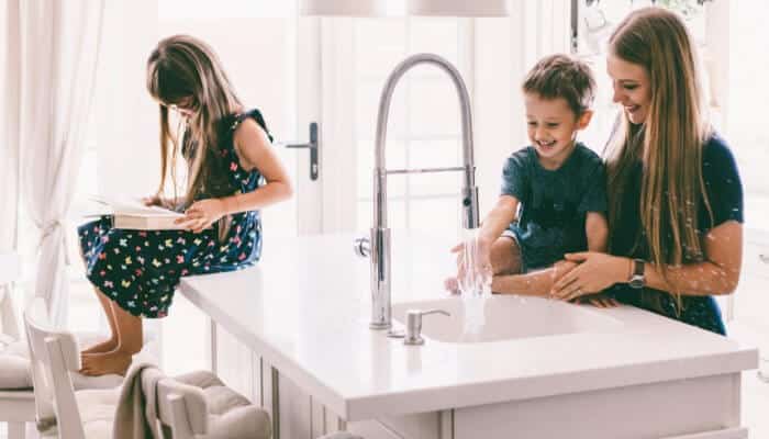 Family In Kitchen With Water Running